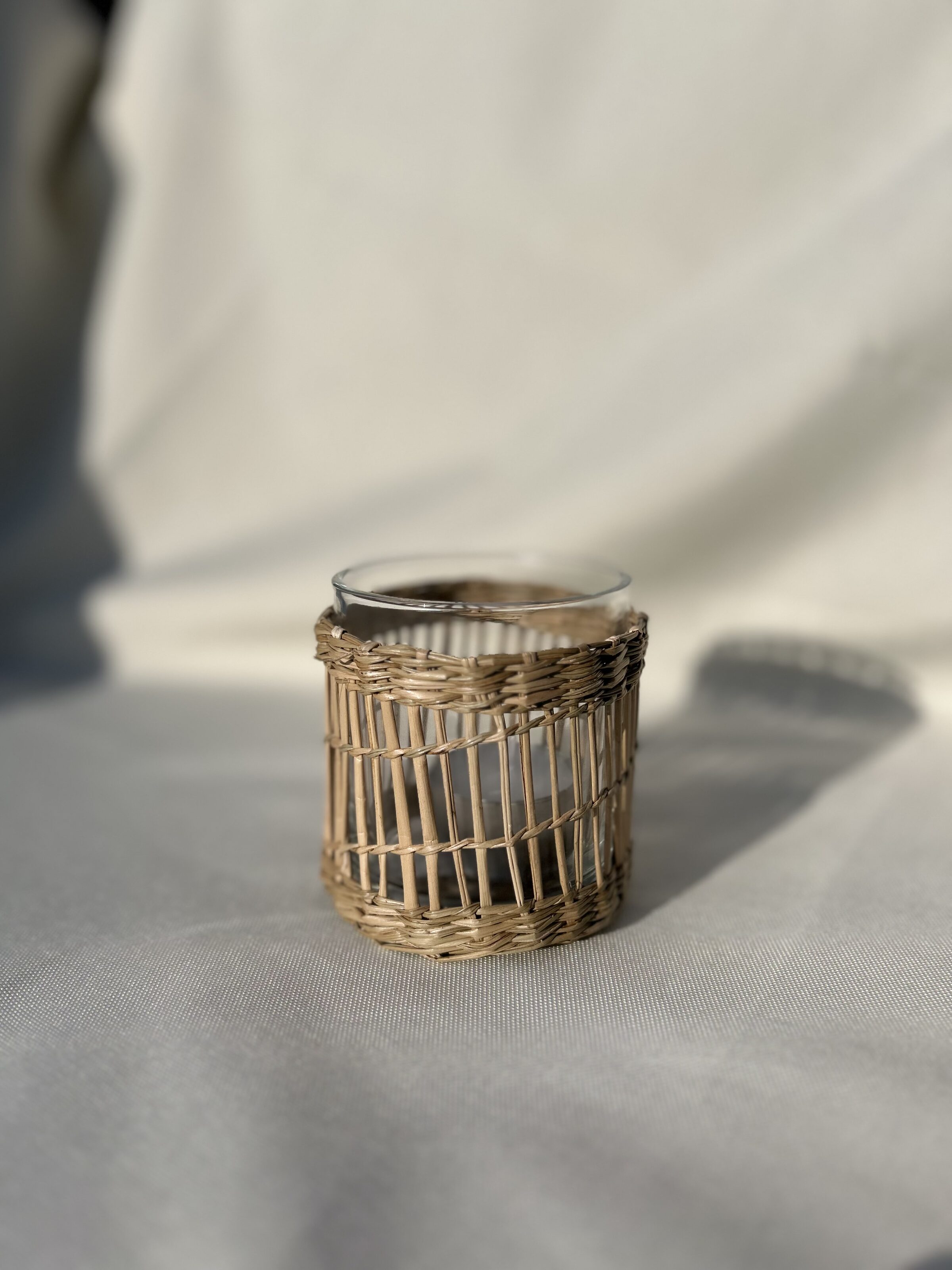 Boho-Teelichtglas auf hellem Stoff als ruhiges Liebeleih-Detail
